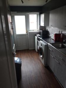 a kitchen with a washing machine and a sink at Hardgate Gardens in Glasgow