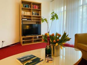 a living room with a table with a bottle of wine and flowers at Haus Kastell - Suite Strandglück in Ahlbeck