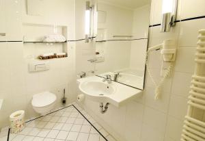 a white bathroom with a sink and a toilet at Haus Kastell - Suite Strandglück in Ahlbeck +14 photos