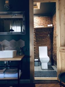 uma casa de banho com um WC branco e um lavatório. em Cozy&stylish Loft em Tbilisi