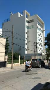 a man riding a motorcycle in front of a building at Hotel Plaza Andalgala in Andalgalá