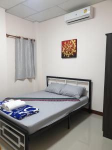 ein Schlafzimmer mit einem Bett in einem Zimmer in der Unterkunft TP home in Bangkok