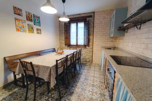 eine Küche mit einem Tisch und Stühlen im Zimmer in der Unterkunft El Reinazu in Cangas de Onís