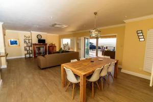 a dining room with a wooden table and chairs at Waterberry 5 in Plettenberg Bay