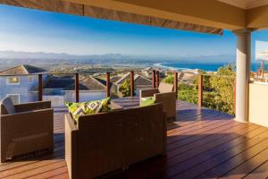 a deck with chairs and a view of the ocean at Waterberry 5 in Plettenberg Bay