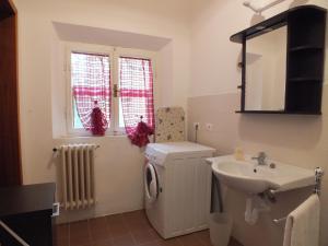 a bathroom with a sink and a washing machine at Villa Mattera in Marina di Campo