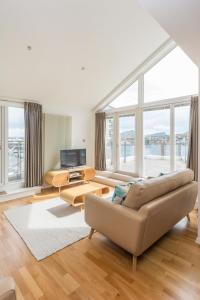 a living room with a couch and a large window at 403 Portland Gardens Penthouse Apartment in Edinburgh
