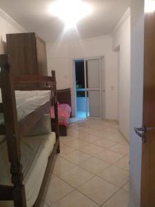 a room with bunk beds and a room with a bedroom at Apartamento Praia Grande Pé na areia in Solemar