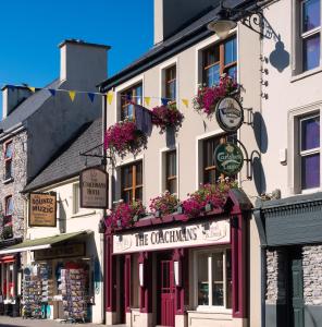 a building with flower boxes on the front of it at Coachmans Townhouse Hotel in Kenmare