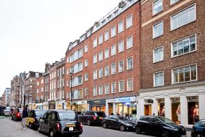 a city street with cars parked in front of buildings at Marylebone Apartments in London