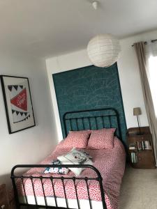 Schlafzimmer mit einem Bett mit einem grünen Kopfteil in der Unterkunft Gite Chez Ginger in Pézenas
