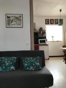 a living room with a couch and a kitchen at Gite Chez Ginger in Pézenas