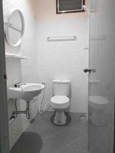 ein weißes Bad mit einem WC und einem Waschbecken in der Unterkunft TP home in Bangkok