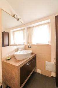 La salle de bains est pourvue d'un lavabo et d'un grand miroir. dans l'établissement Terrazze del Lungomare, à Naples