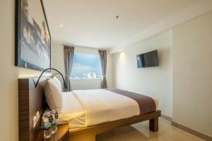 a hotel room with a bed and a window at SUPER OYO Collection O Hotel Pasar Baru Heritage in Bandung
