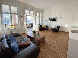 ein Wohnzimmer mit einem Sofa und einem Tisch in der Unterkunft Villa Anna - Carpe Diem in Heringsdorf