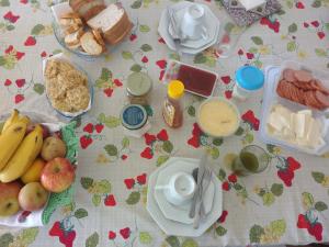 a table with breakfast food and fruit on it at Um quarto em casa agradável in Perequê
