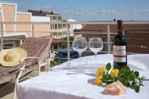 a table with a bottle of wine and two glasses at Altera Guest House in Popovka
