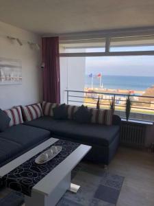 ein Wohnzimmer mit einem Sofa und Meerblick in der Unterkunft Strandhotel Wohnung 30 in Dahme