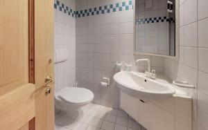 Un baño blanco con inodoro y lavabo. en Adrisa 11, en St. Moritz 12 fotos más