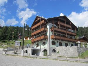 un bâtiment avec des balcons sur le côté d'une montagne dans l'établissement RTA Torre Del Brenta, à Madonna di Campiglio