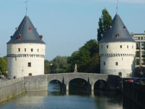 two white towers and a bridge over water at Apartment casuaLLoft in Kortrijk