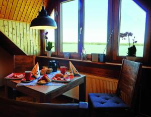 a table with food on it in a room with windows at Blick auf den Bodden in Ribnitz-Damgarten