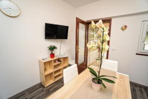a dining room with a table and a clock on the wall at Apartman Dea in Crveni Vrh