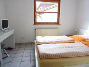 Schlafzimmer mit einem Bett, einem Fenster und einem Schreibtisch in der Unterkunft Haus am Wasserfall in Sankt Anton im Montafon