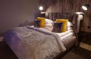 a bedroom with a large bed with yellow pillows at Malmaison London in London