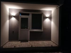 a room with a window and two lights on the wall at Apartment Nina in Stará Ľubovňa