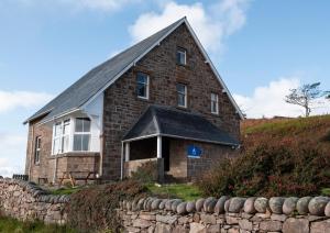 stary ceglany dom z kamienną ścianą w obiekcie Gairloch Sands Youth Hostel w mieście Gairloch