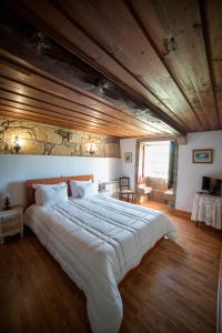 ein großes Bett in einem Schlafzimmer mit Holzdecke in der Unterkunft Casa de Sta Comba in Barcelos