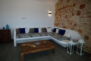 a couch in a room with a brick wall at Villa Chelidonia in Karpathos