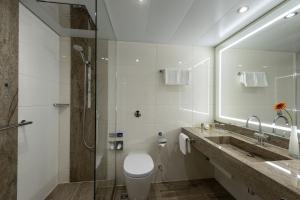 a bathroom with a toilet and a sink and a shower at Maritim Hotel Bremen in Bremen +59 photos