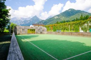 a tennis court with mountains in the background at Jutel Hinterstoder in Hinterstoder