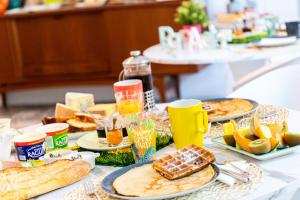 - une table avec des assiettes de nourriture et de boissons dans l'établissement Le 49 Côté Parc & SPA, à Domblans