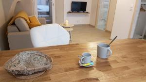 a living room with a table with two mugs on it at Les insolites de Champeix in Champeix