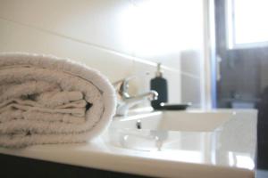 un mucchio di asciugamani seduti sopra un lavandino del bagno di D. João I Apartment ad Almada