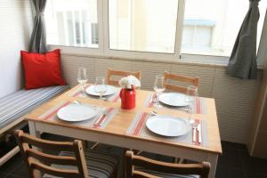 een houten tafel met borden en wijnglazen erop bij D. João I Apartment in Almada