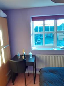 1 dormitorio con mesa, cama y ventana en Double Room in Honiton House, en Hendon