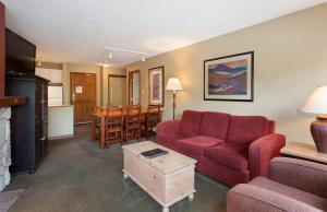 a living room with a red couch and a table at The Aspens by Whistler Premier in Whistler