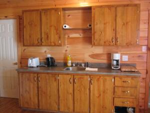 a kitchen with wooden cabinets and a sink at Princehaven Campground in Princeton