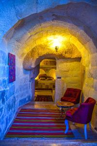 een kamer met een bank en een tafel in een tunnel bij Cappadocia Cave House in Urgup