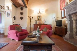 a living room with two red chairs and a fireplace at Olivella in Campagnano di Roma