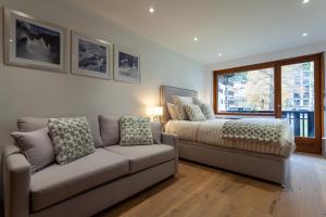- un salon avec un canapé et un lit dans l'établissement Apartment Brevent Fodera, à Chamonix-Mont-Blanc