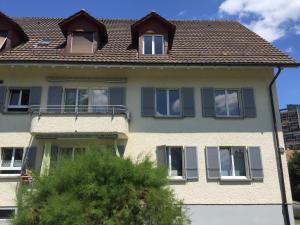 ein Haus mit blauen Fenstern und einem Dach in der Unterkunft Ferienwohnung in Bern in Bern