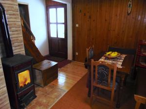 a living room with a wood stove and a table at Vikendica Sekulić in Bajina Bašta