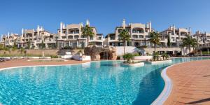 a swimming pool in front of a resort at Shantiapartments in Vilamoura