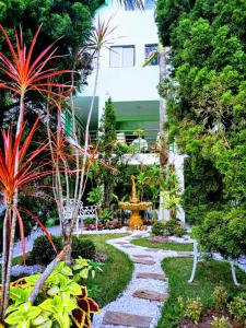 een tuin met palmbomen en een stenen pad bij Hotel Pousada Reimar in Balneário Camboriú